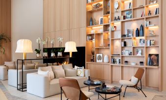 a modern living room with a white couch , two chairs , and a bookshelf filled with books at Riviera Marriott Hotel la Porte de Monaco