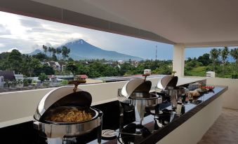 a buffet table with a variety of food items and a view of a mountain at Victoria Inn