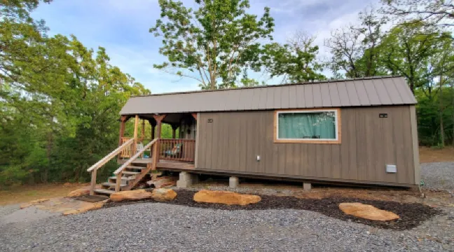 Cozy tiny cabin nested in the trees in a lake community, peaceful countryside.