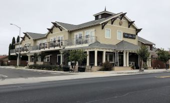 "a large building with multiple balconies and a sign reading "" olive "" is located on the corner of a street" at Wine Stone Inn
