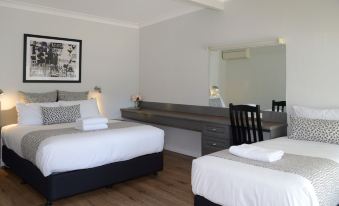 a modern hotel room with two beds , a desk , and a mirror , all neatly arranged at Myrtleford Motel on Alpine