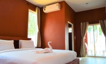 a cozy bedroom with a white bed and an air conditioner on the wall , creating a warm and inviting atmosphere at World Cat Hotel Beach & Resort