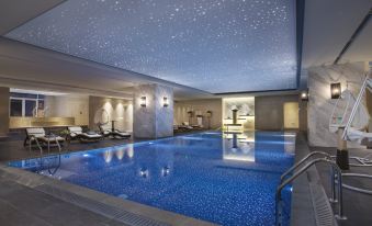a large indoor swimming pool with a ceiling that is covered in stars , allowing the room to shine brightly at Somerset Grand Central Dalian