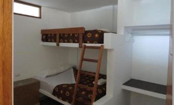a small room with two bunk beds , one on top of the other , and a ladder leading to the top bunk at Costa Esmeralda