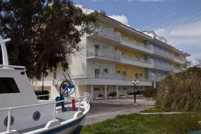 a white building with balconies and a blue building with an anchor on the side at Hotel Summery