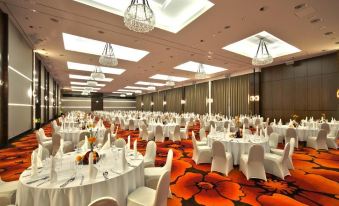 a large , well - decorated banquet hall with multiple tables covered in white tablecloths and chairs arranged for a formal event at Hotel Warszawianka