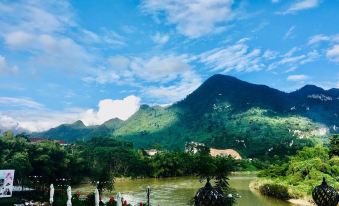 a serene scene of a river flowing through a mountainous landscape , with a restaurant on the other side of the river at Phoenix Hotel