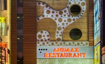 a modern building with an entrance and signage for the andaaz restaurant , as well as a grand empyre hotel in the background at Emporio Hotel