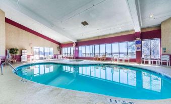 an indoor swimming pool with a view of the ocean , surrounded by lounge chairs and tables at Siegel Select Bartlett Extended Stay in Tennessee