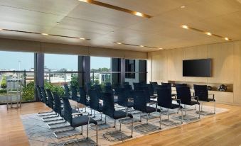 a large conference room with rows of chairs arranged in a semicircle , facing a large screen at Hotel Sa Barrera - Adults Only