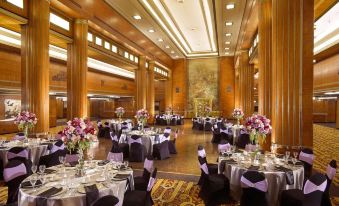 a large banquet hall with multiple tables set up for a formal event , possibly a wedding reception at The Queen Mary