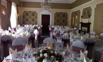 a well - decorated banquet hall with multiple tables set for a formal event , including elegant decorations and flowers at Hardwicke Hall Manor Hotel