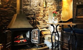 a cozy living room with a fireplace and a dining table in front of it at The Nobody Inn