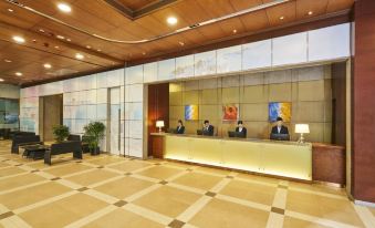 The entryway features a lobby with people seated at the front desk and on either side at Hotel COZI Harbour View