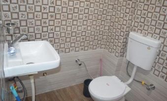 a small bathroom with a toilet and sink , decorated with white and brown tiles on the wall at The Village
