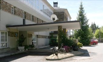 a large building with a sign above the entrance and a bicycle in front of it at Pousada de Portomarin