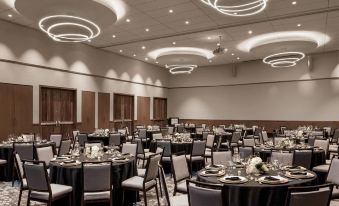 a large dining room with multiple round tables and chairs , creating a pleasant atmosphere for a special event at The Civic Hotel