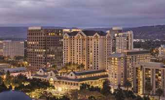 a cityscape with tall buildings lit up at night , including a large hotel and a city skyline at Signia by Hilton San Jose