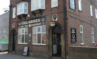 "a brick building with a sign that says "" u the shoes bar & restaurant "" on it" at The Shoes