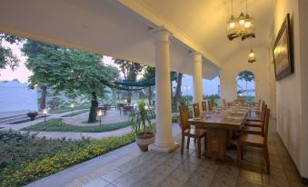 a long dining table set up for a formal dinner , with multiple chairs arranged around it at Metland Hotel Cirebon by Horison