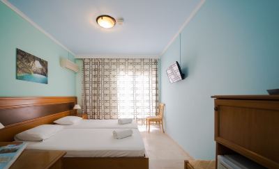 a hotel room with two beds , one on the left and one on the right side of the room at Hotel Summery