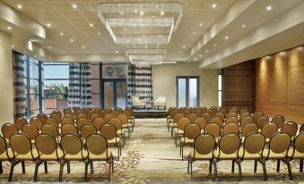 a large conference room with rows of chairs arranged in a semicircle , ready for an event at Hilton Windhoek