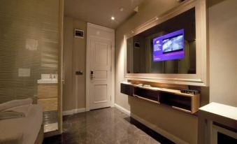 a modern bathroom with a large television mounted on the wall , a sink , and a bathtub at Upper House Hotel