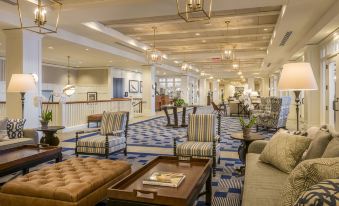 a large hotel lobby with multiple couches and chairs , creating a comfortable seating area for guests at Beauport Hotel Gloucester