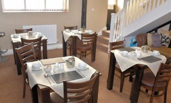 a dining room with multiple tables and chairs arranged for a group of people to enjoy a meal together at The Red Lion