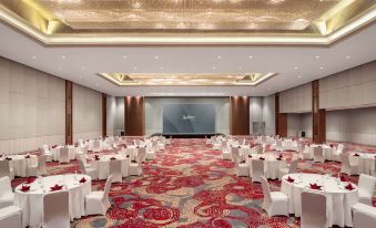 a large banquet hall with white tables and chairs set up for a formal event at Radisson Lampung Kedaton