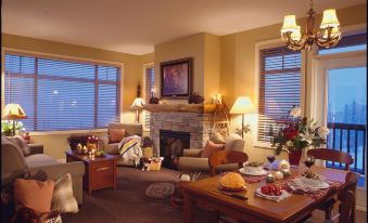 a cozy living room with a fireplace , comfortable seating , and a dining table set for breakfast at Sundance Resort