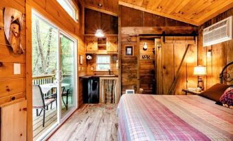 a cozy wooden cabin with a bed , kitchen , and dining area , giving a rustic and cozy atmosphere at The Owl's Perch