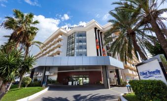 "a hotel with a red sign that says "" les terrasses "" is surrounded by palm trees" at Hotel Best Tenerife