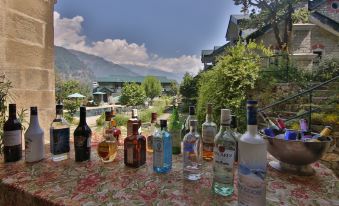 a table with various bottles of alcohol and a blanket in front of a mountain view at The Himalayan