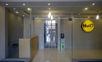 a glass door with a yellow circle logo and a man in a yellow shirt standing at the entrance at RedDoorz Syariah @ Jalan Sultan Agung Tegal