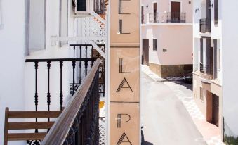 a wooden sign for a hotel la palma is displayed on the side of a building at La Palmera Rooms