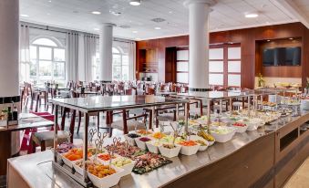 a large dining room with multiple tables filled with various food items and utensils , creating an inviting atmosphere for guests at Oliva Nova Beach & Golf Hotel