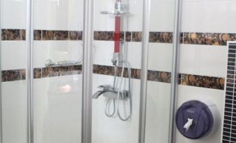 a shower with a red and white patterned wall is shown in the image at Mostar Hotel