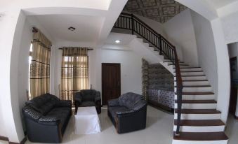 a living room with a couch , chairs , and a staircase leading to an upstairs area at Heaven Rest