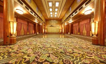 a grand , spacious room with carpeted floor and wooden walls , featuring large windows , chandeliers , and large screens at The Queen Mary