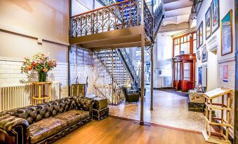 a large , elegant living room with high ceilings and a staircase leading to the second floor at Hotel New York