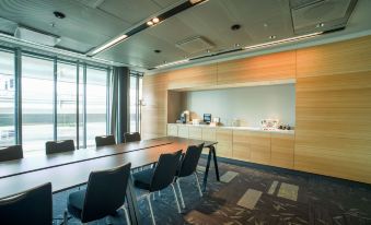 a conference room with a long table and chairs , large windows , and a counter with various items at Radisson Blu Waterfront Hotel, Stockholm