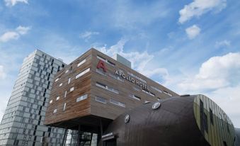 "a modern building with a large glass wall and the words "" higher education "" written in red" at Leonardo Hotel Almere City Center