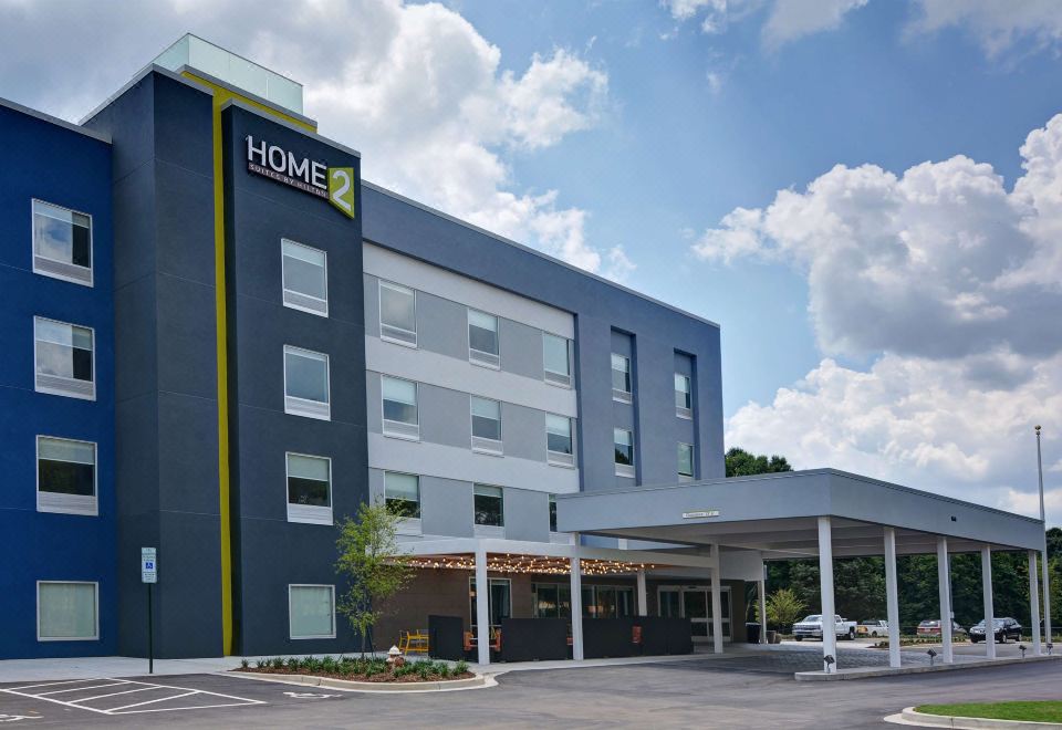 "a modern , blue and white hotel with the word "" home "" on the side , under a clear sky" at Home2 Suites by Hilton Fort Mill