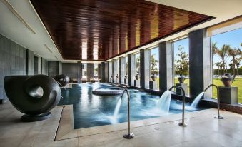 a modern indoor swimming pool with multiple pools and water features , surrounded by wooden ceiling beams at Dusit Thani LakeView Cairo