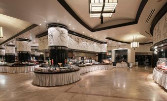 a large buffet - style dining area with a long buffet table filled with various food items and utensils at Lykia World Antalya