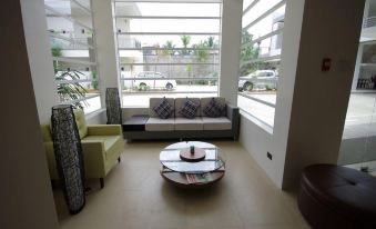 a modern living room with white walls , large windows , and a circular coffee table in the center at Yhotel