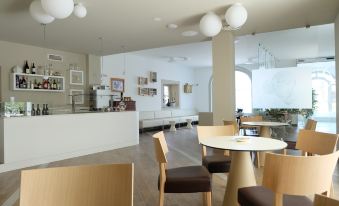 a modern restaurant with a white reception desk , wooden tables and chairs , and pendant lights at Hotel Monteverde