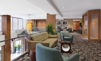 a modern hotel lobby with various seating options , including couches and chairs , as well as a dining table at The Moonrise Hotel