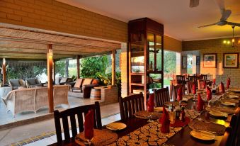 a dining room with a long table set for a meal , surrounded by chairs and a couch at River View Lodge